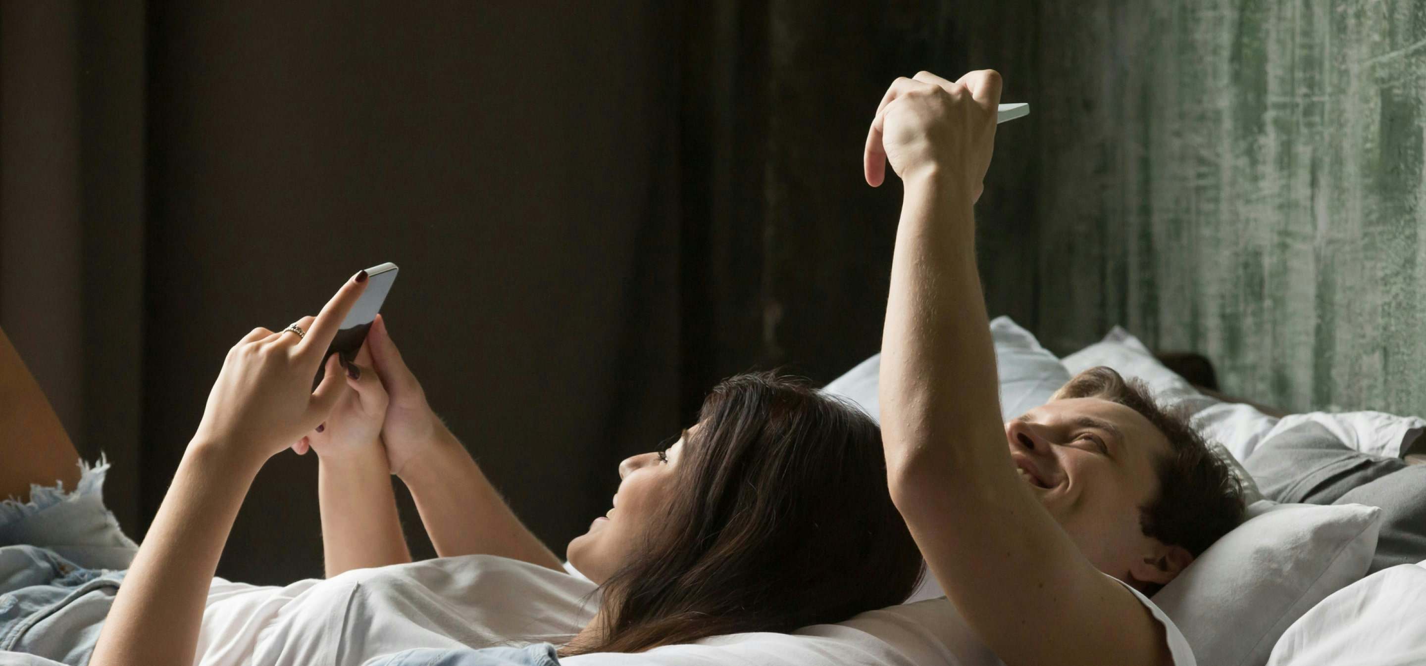 Couple on bed using phones