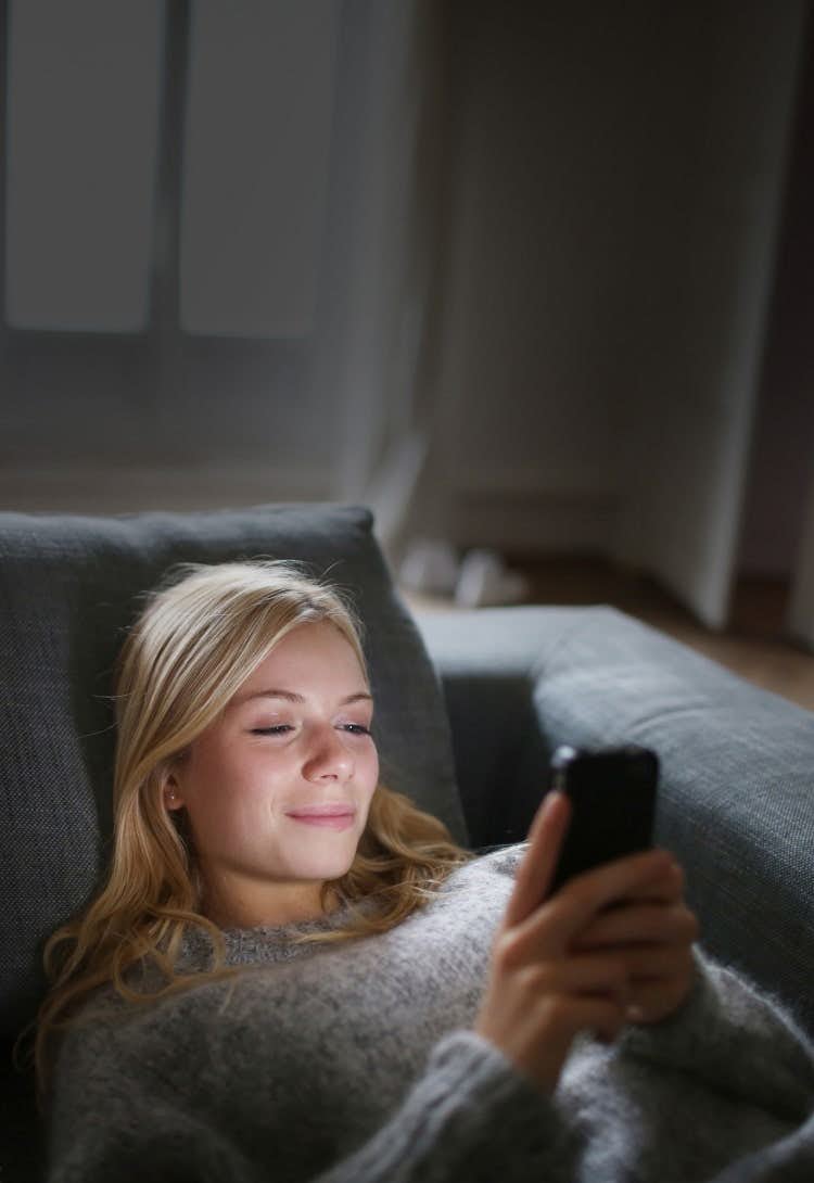 Woman on couch using phone