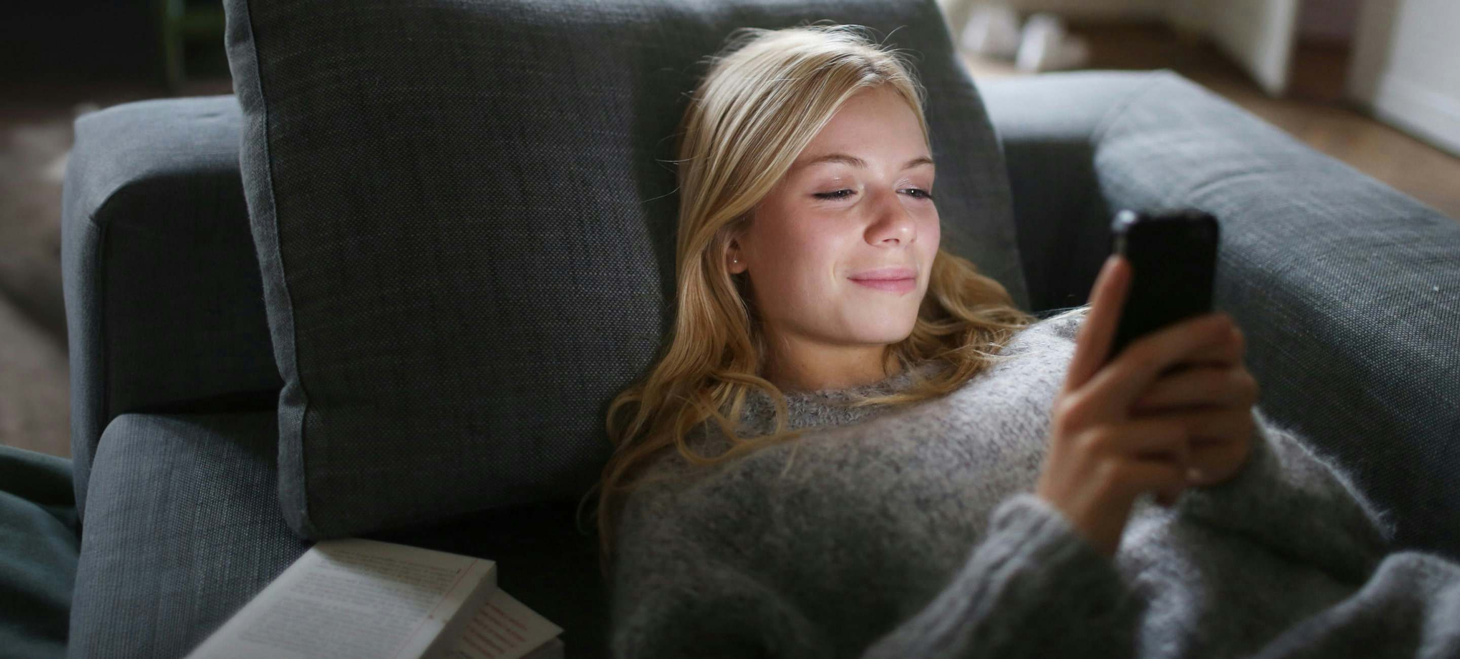Woman on couch using phone