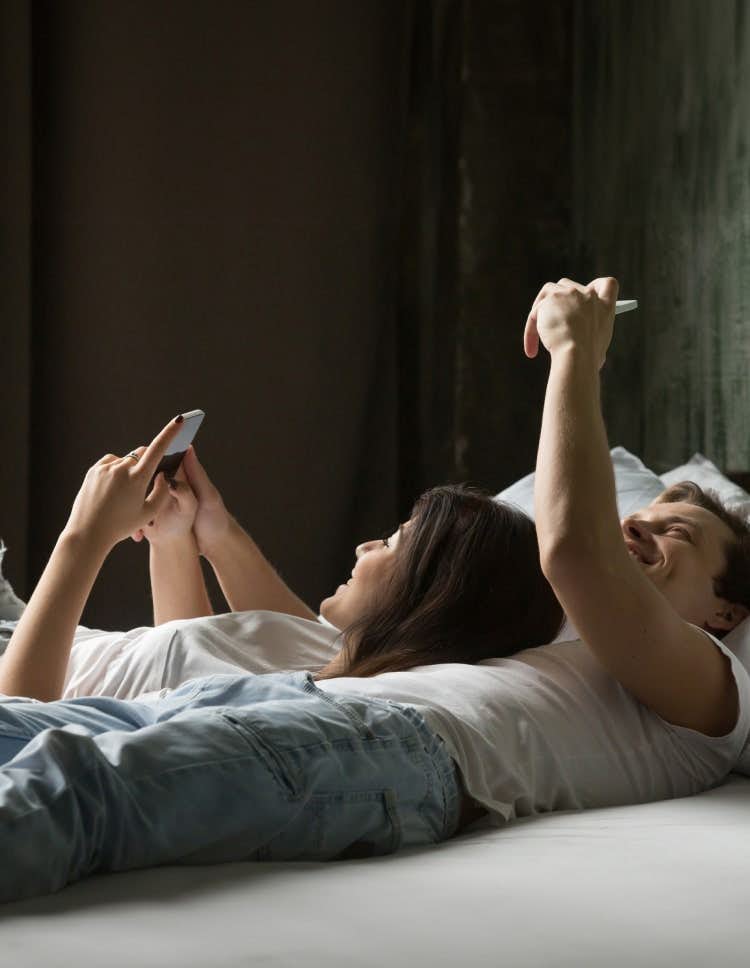 Couple on bed using phones